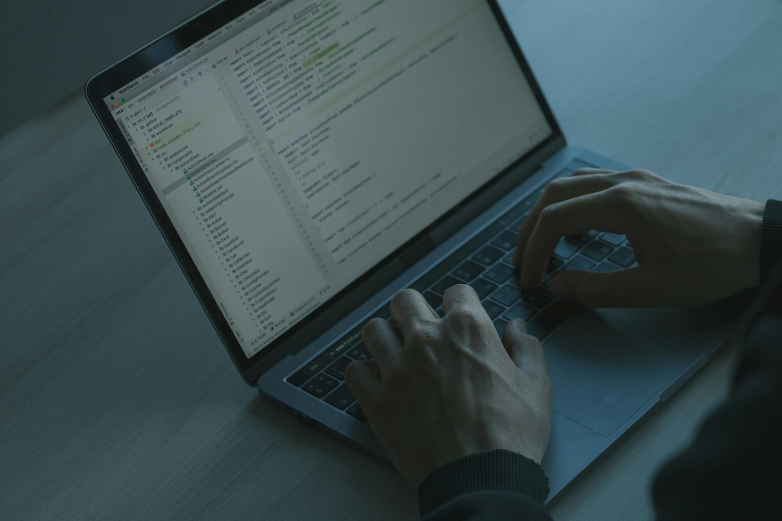 Zbliżenie na dłonie programisty piszącego kod na laptopie w chłodnym, kinowym oświetleniu – profesjonalne oferty pracy dla Senior Developerów na cvsearch.pl.