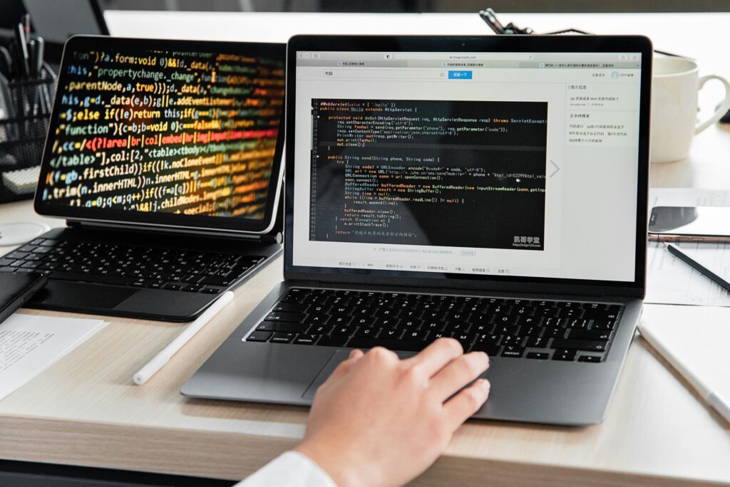Stanowisko pracy programisty z laptopem i tabletem wyświetlającym kod źródłowy – oferty pracy IT i rozwój w sektorze tech na cvsearch.pl