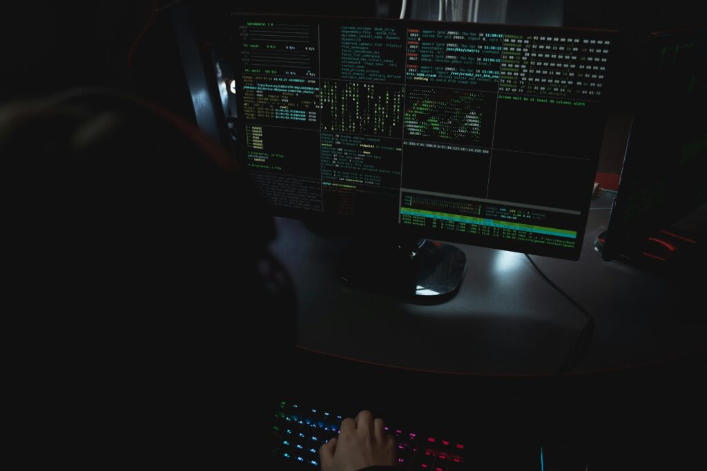 Stanowisko pracy programisty z wieloma monitorami w ciemnym pokoju – kodowanie, cybersecurity i nocne zmiany IT na cvsearch.pl