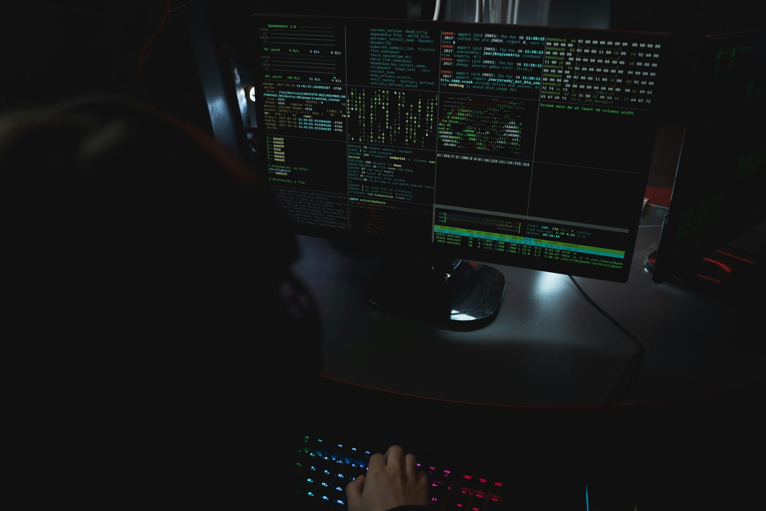 Stanowisko pracy programisty z wieloma monitorami w ciemnym pokoju – kodowanie, cybersecurity i nocne zmiany IT na cvsearch.pl