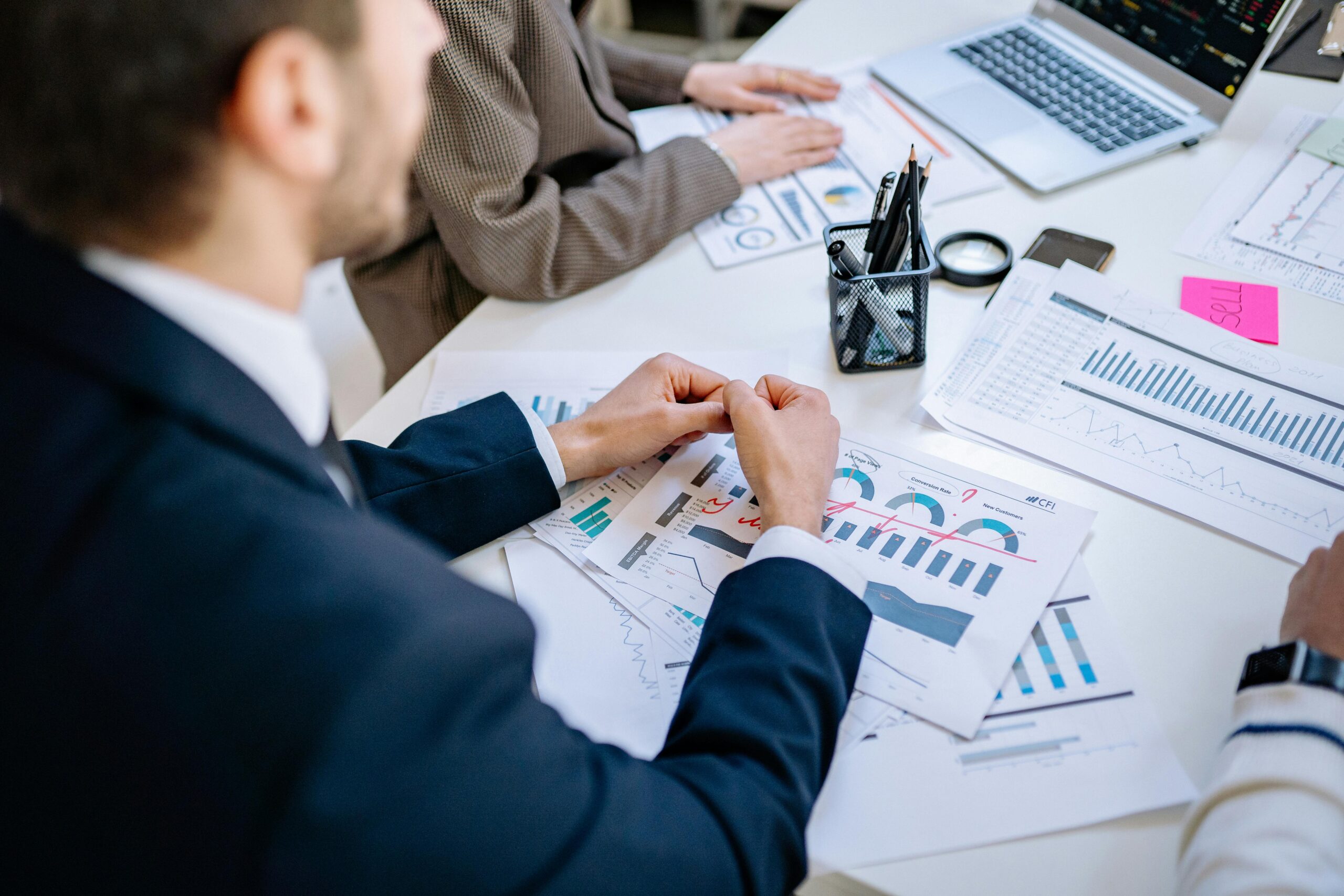 Tekst alternatywny: Specjaliści w garniturach analizujący wykresy i raporty finansowe podczas spotkania biznesowego – rekrutacja analityków i strategów na cvsearch.pl